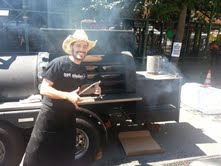 Ari WHite in front of his portable truck where he smokes his meat for days at a time.
